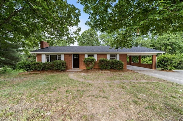 ranch-style home with brick siding, a chimney, driveway, a front yard, and an attached carport