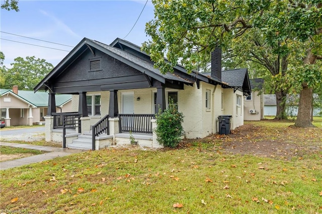 bungalow-style house with a front lawn and covered porch