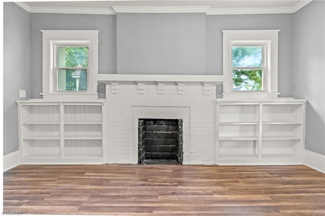 unfurnished living room featuring crown molding, a wealth of natural light, hardwood / wood-style floors, and a brick fireplace