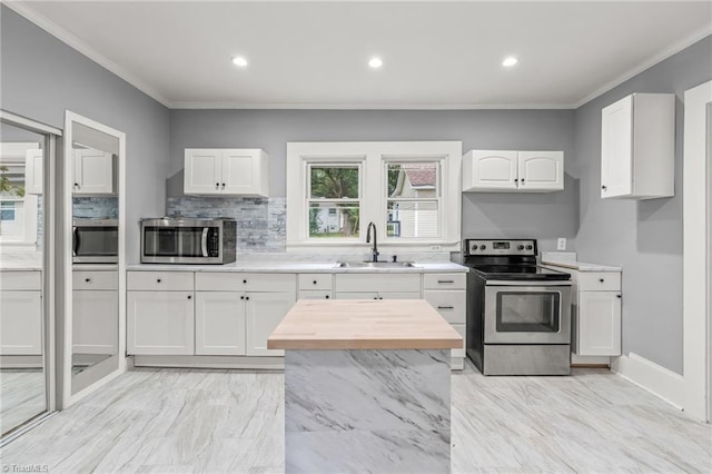 kitchen with white cabinets, stainless steel appliances, sink, and a healthy amount of sunlight