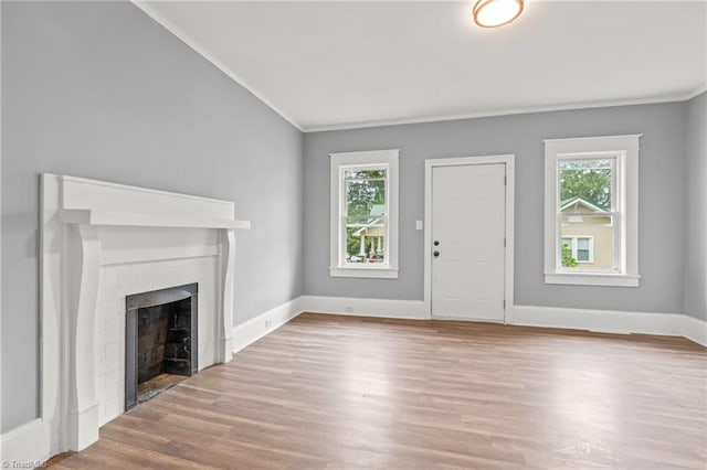 unfurnished living room with light hardwood / wood-style floors, a fireplace, and ornamental molding