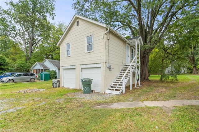 view of side of property with a lawn and a garage