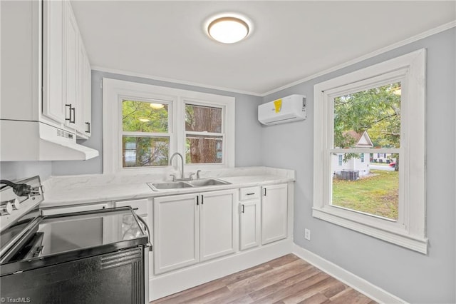 kitchen with white cabinets, sink, stainless steel range with electric cooktop, light wood-type flooring, and a wall mounted air conditioner