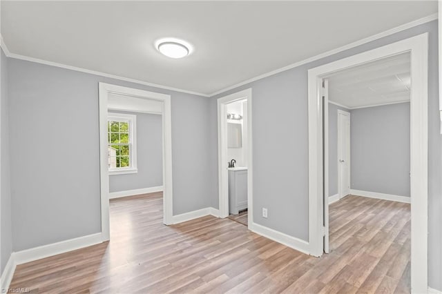 spare room featuring crown molding and light hardwood / wood-style floors