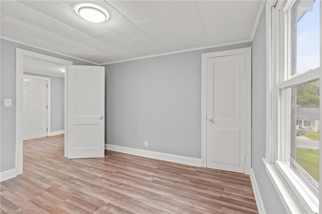 empty room featuring crown molding and light hardwood / wood-style floors