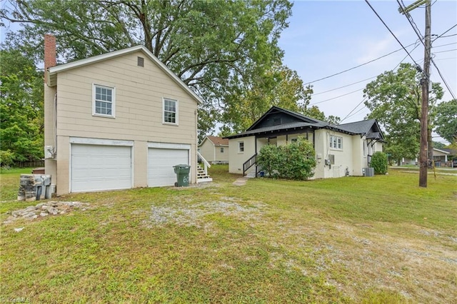 view of side of property featuring a garage, a yard, and central air condition unit