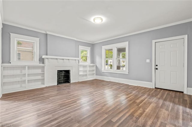 unfurnished living room with hardwood / wood-style flooring, a fireplace, and crown molding