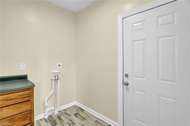 washroom featuring light wood-type flooring and electric dryer hookup