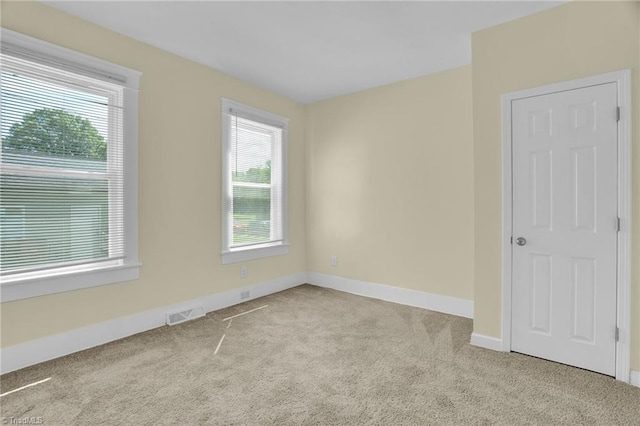 unfurnished room featuring visible vents, baseboards, and carpet flooring