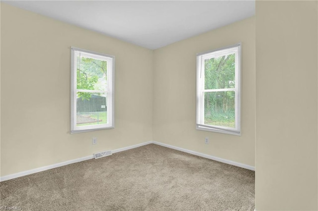 spare room featuring visible vents, carpet flooring, and baseboards