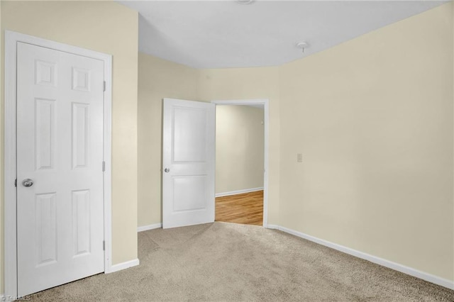 unfurnished bedroom featuring baseboards and carpet