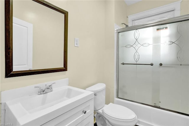 full bathroom featuring shower / bath combination with glass door, vanity, and toilet