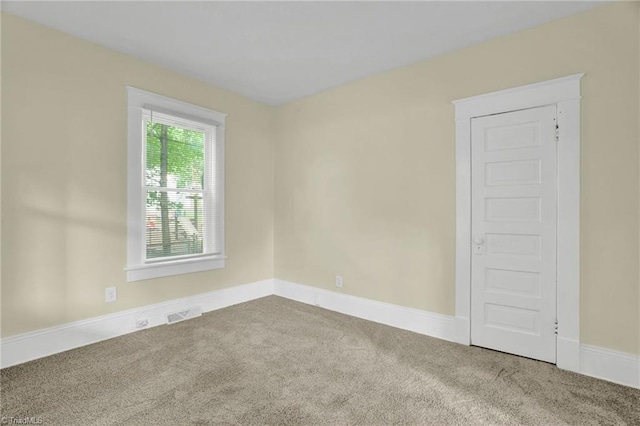 carpeted empty room featuring baseboards