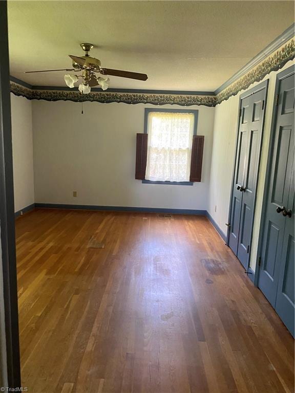 1229 Woodbrook Dr, Kernersville, NC 27284 - empty room with wood finished floors, a ceiling fan, baseboards, and crown molding