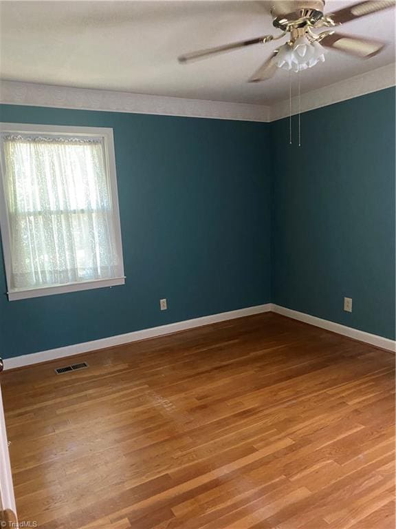 1229 Woodbrook Dr, Kernersville, NC 27284 - spare room featuring wood finished floors, ceiling fan, and baseboards