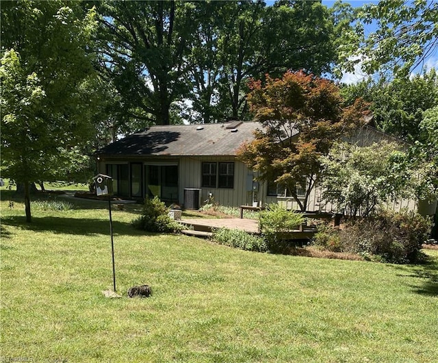 1229 Woodbrook Dr, Kernersville, NC 27284 - view of front facade featuring board and batten siding, a front lawn, and central AC