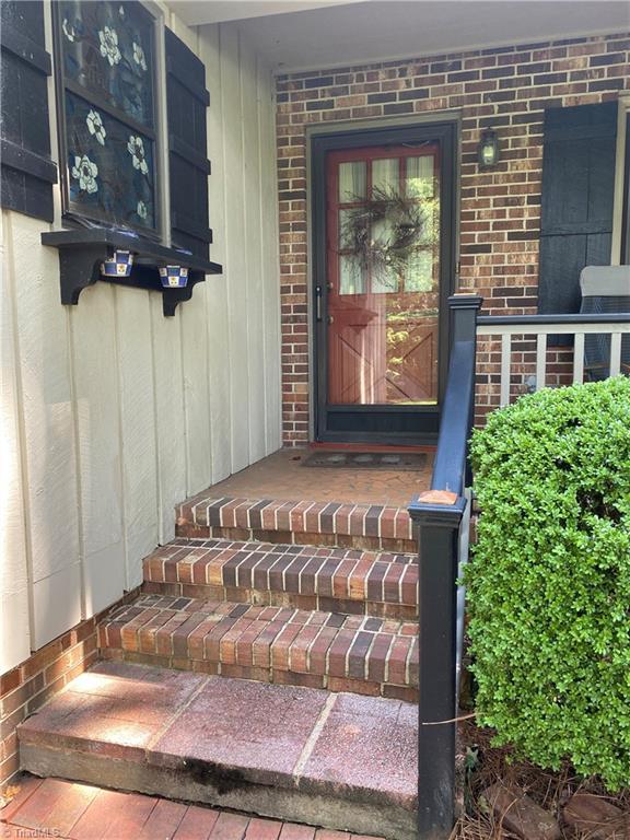 1229 Woodbrook Dr, Kernersville, NC 27284 - doorway to property with brick siding and a porch