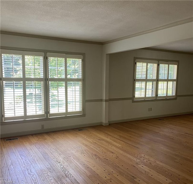 1229 Woodbrook Dr, Kernersville, NC 27284 - spare room with light wood-style flooring, a textured ceiling, baseboards, healthy amount of natural light, and ornamental molding