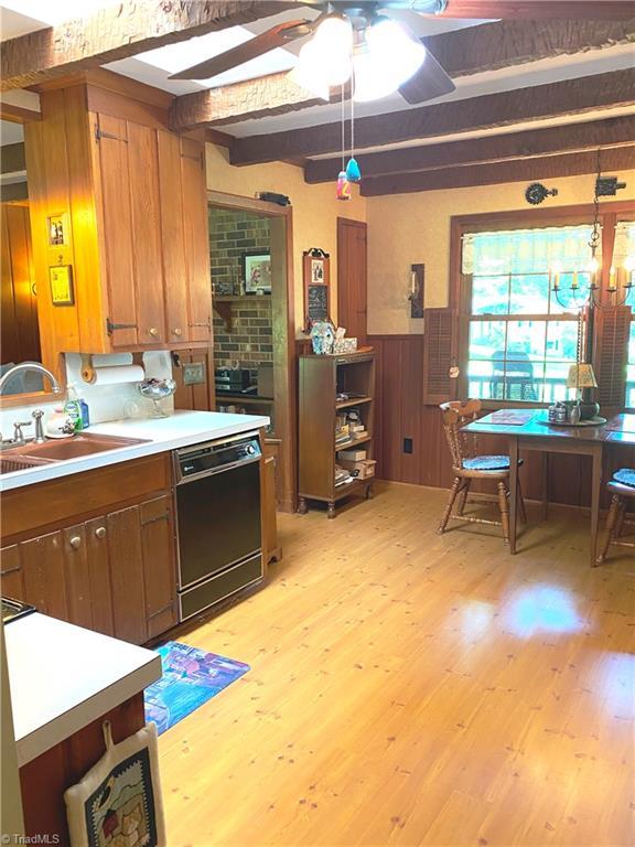 1229 Woodbrook Dr, Kernersville, NC 27284 - kitchen with dishwasher, a sink, beam ceiling, light wood finished floors, and light countertops
