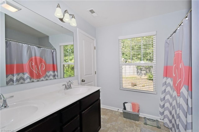 bathroom with a shower with shower curtain, a wealth of natural light, and vanity