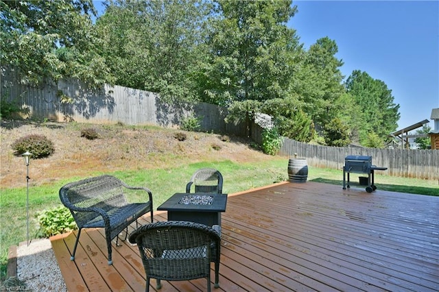 deck with grilling area and a fire pit