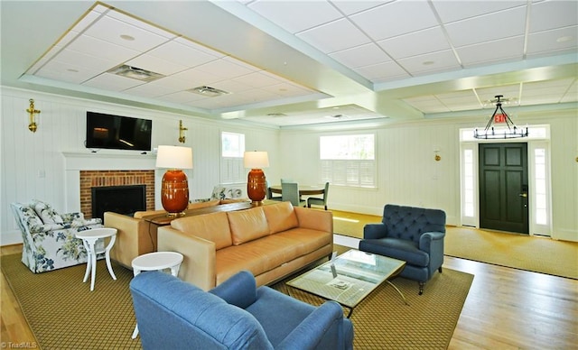 living room with a paneled ceiling, light wood-type flooring, and a fireplace