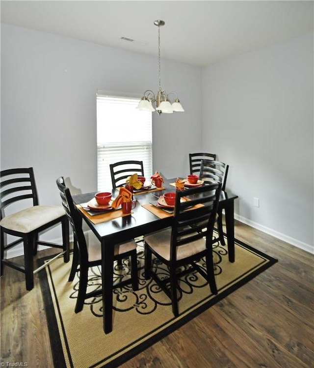 dining space featuring a chandelier and dark hardwood / wood-style floors