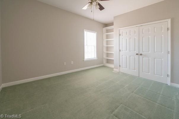 unfurnished bedroom featuring ceiling fan, a closet, carpet, and baseboards