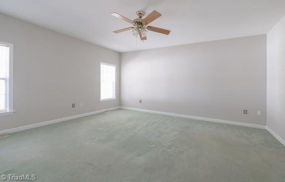 spare room featuring carpet floors, baseboards, and a ceiling fan