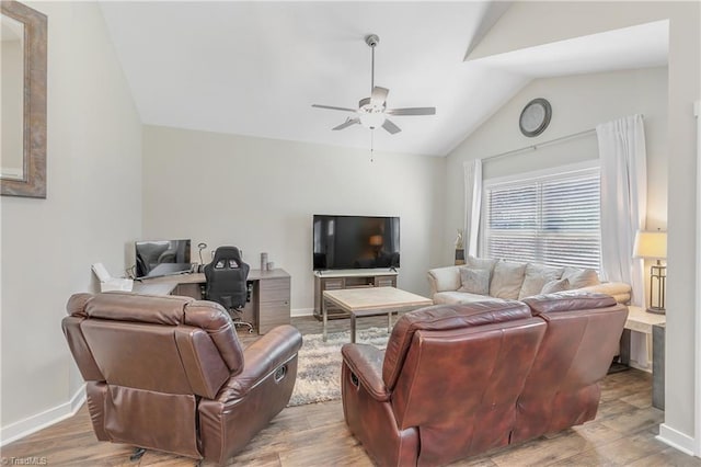 living area featuring vaulted ceiling, light wood-style flooring, a ceiling fan, and baseboards