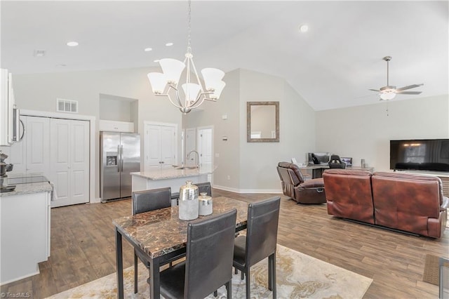 dining room featuring visible vents, recessed lighting, ceiling fan with notable chandelier, wood finished floors, and high vaulted ceiling