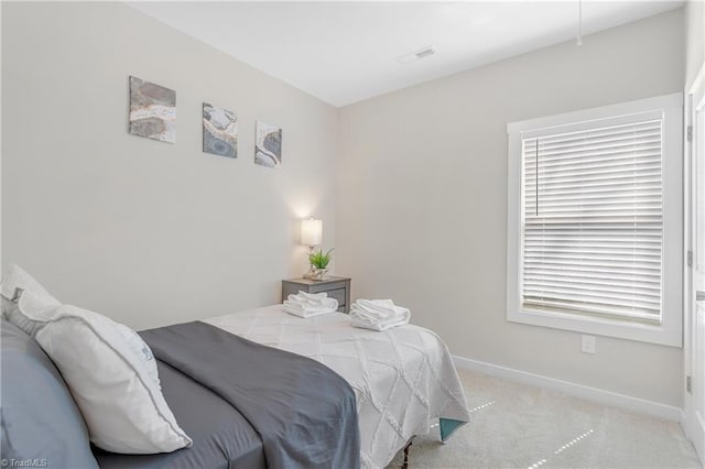 bedroom with light carpet, visible vents, and baseboards