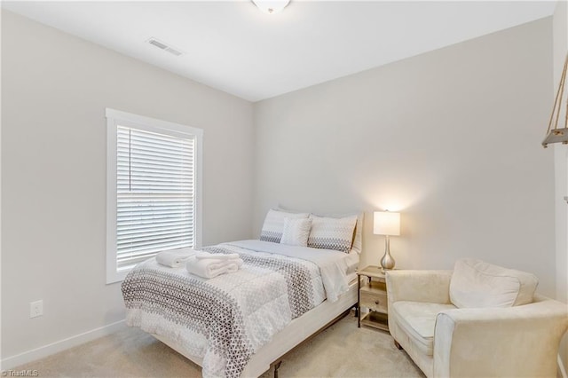 bedroom with light colored carpet, visible vents, and baseboards