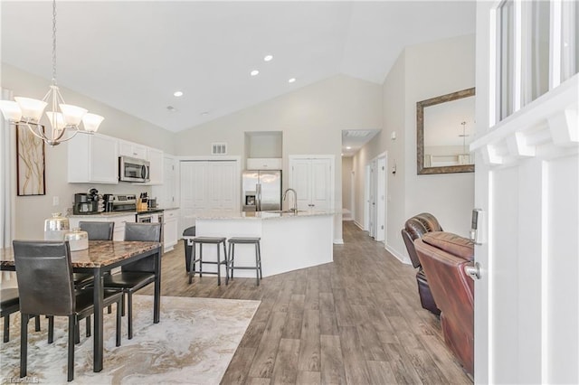 dining space with visible vents, high vaulted ceiling, recessed lighting, light wood-style floors, and a chandelier