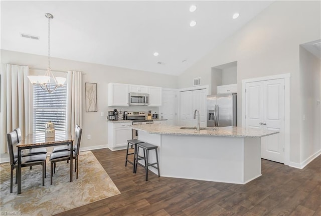 kitchen featuring visible vents, a notable chandelier, a kitchen island with sink, a sink, and stainless steel appliances