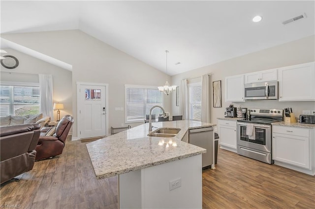 kitchen with visible vents, open floor plan, an inviting chandelier, stainless steel appliances, and a sink