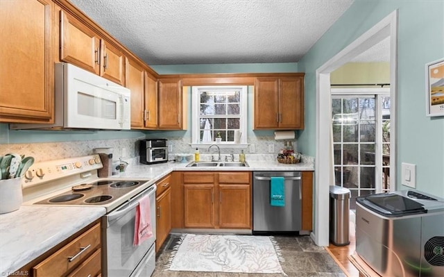 kitchen featuring a textured ceiling, sink, and white appliances