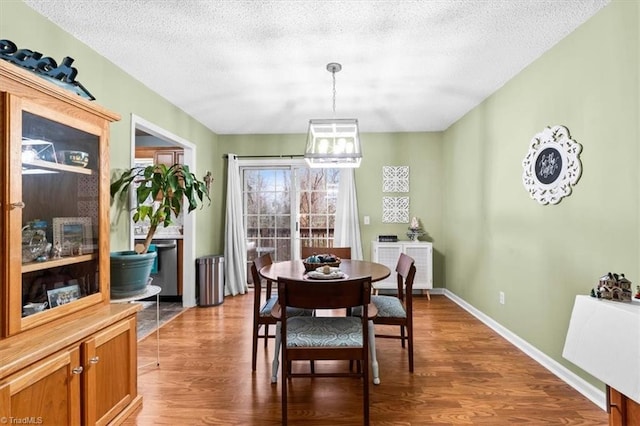 dining space featuring a textured ceiling and hardwood / wood-style flooring