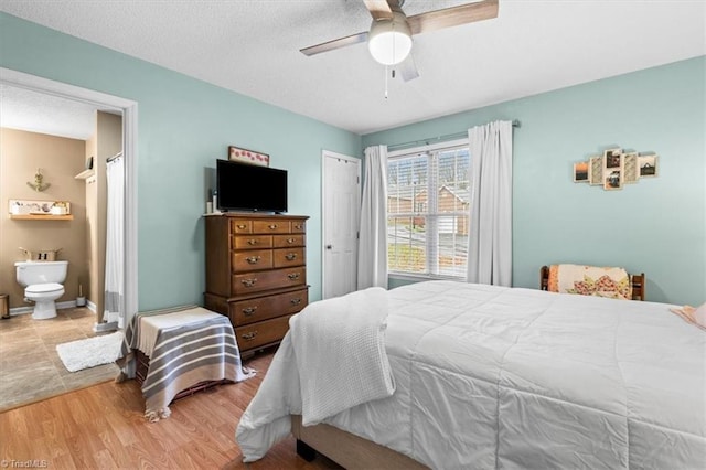 bedroom with ceiling fan, light hardwood / wood-style floors, and connected bathroom