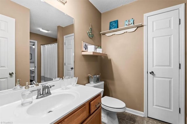 bathroom featuring tile patterned floors, vanity, toilet, and a textured ceiling