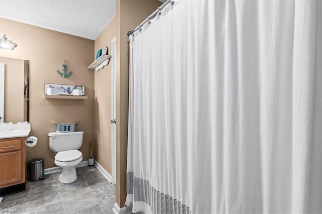 bathroom featuring vanity, a textured ceiling, and toilet