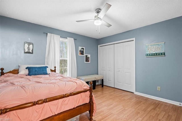 bedroom with ceiling fan, a closet, a textured ceiling, and light hardwood / wood-style flooring