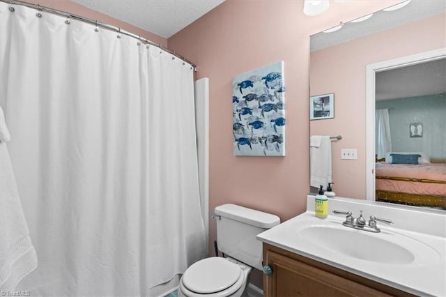 bathroom with vanity, a textured ceiling, and toilet