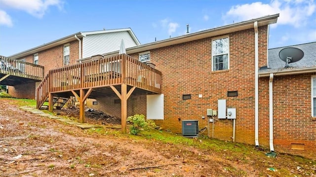 rear view of property featuring central air condition unit and a wooden deck