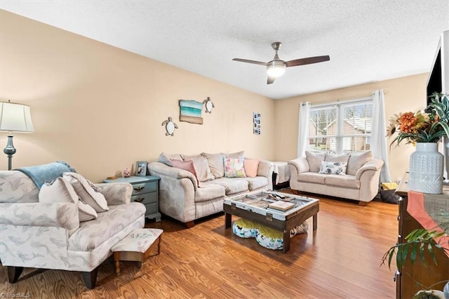 living room featuring a textured ceiling, light hardwood / wood-style floors, and ceiling fan