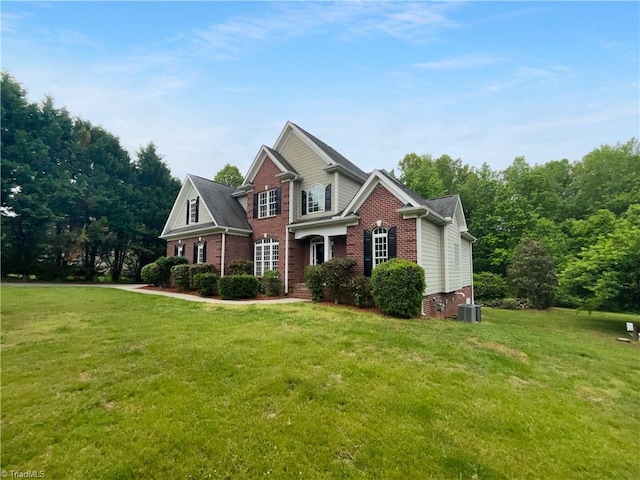 view of front of home featuring brick siding, a front lawn, and central AC unit