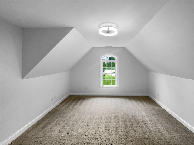 additional living space featuring carpet flooring, vaulted ceiling, and baseboards