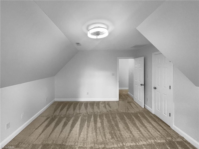 additional living space featuring carpet flooring, vaulted ceiling, and baseboards