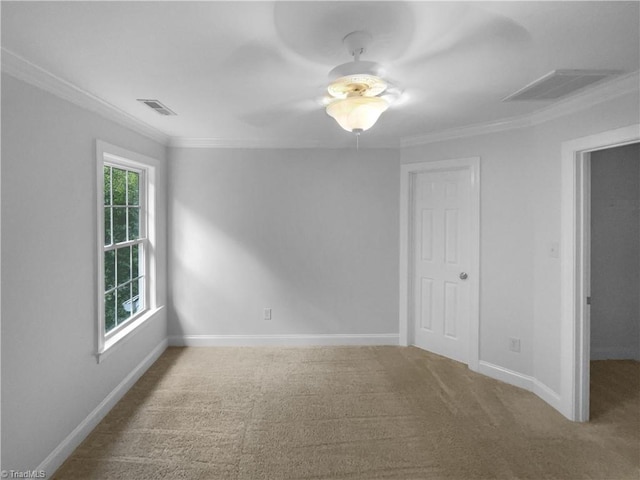 carpeted empty room with ornamental molding and baseboards