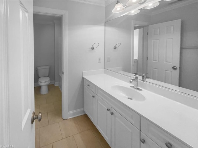bathroom featuring toilet, crown molding, tile patterned floors, vanity, and baseboards